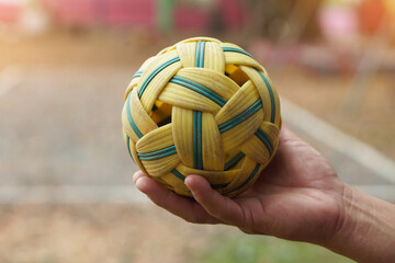 Closeup man hold Sepak Takraw ball outdoor. Concept, Asian traditional sport. A ball made of rattan...