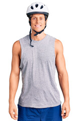 Young handsome man wearing bike helmet with a happy and cool smile on face. lucky person.