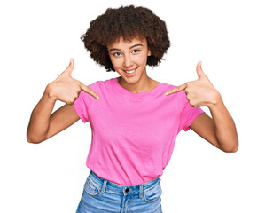 Young hispanic girl wearing casual clothes looking confident with smile on face, pointing oneself with fingers proud and happy.
