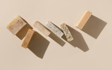Natural herbal beige and brown soap bars on light beige top view, hard shadows