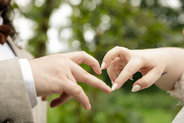 Bräutigam und Braut formen Herz mit ihren Fingern - 688670935