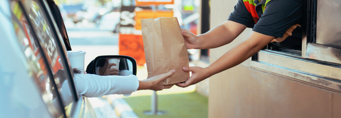 Woman getting fast food at drive-thru - obrazy, fototapety, plakaty