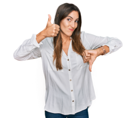 Young beautiful woman wearing casual clothes doing thumbs up and down, disagreement and agreement expression. crazy conflict