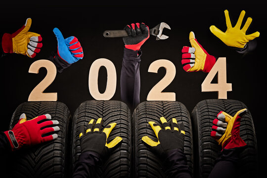 Winter car tires service and hands of mechanics, wrench and text 2024 happy new year on black background.