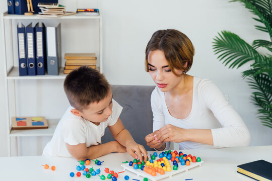 Female psychologist playing educational games with boy
