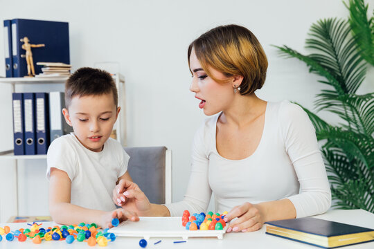 Female psychologist playing educational games with boy