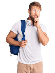 Young caucasian man wearing student backpack and headphones serious face thinking about question...