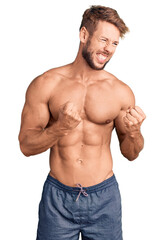 Fototapeta premium Young caucasian man standing shirtless excited for success with arms raised and eyes closed celebrating victory smiling. winner concept.