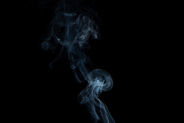incense stick with smoke against black background