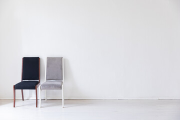 two colorful chairs in the interior of a white empty room
