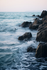 Fototapeta na wymiar Mar com ondas batendo nas rochas ao entardecer - Papel de parede