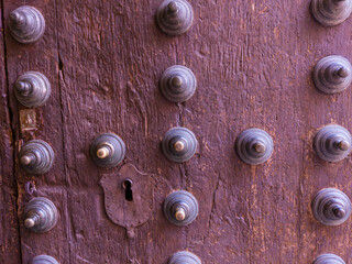 Metal pins on old wooden door