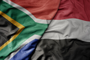 big waving national colorful flag of yemen and national flag of south africa .