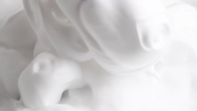 Soapsuds, close up. Hair foam mousse, macro. Beauty background. Close up of white cloud of hair mousse or shaving foam.