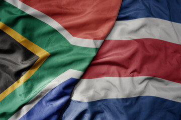 big waving national colorful flag of costa rica and national flag of south africa .
