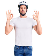 Young handsome man wearing bike helmet relax and smiling with eyes closed doing meditation gesture with fingers. yoga concept.