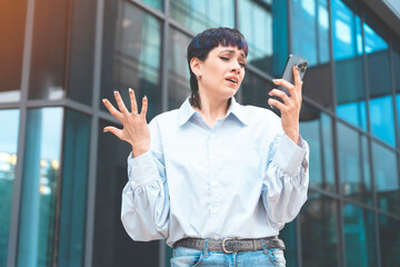 Portrait of a young woman talking in anger on her mobile to her boyfriend about ending their...