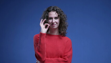 Woman giving OK signal with Hands. Female person in 20s showing approval