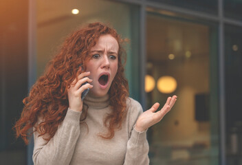 Portrait of a young woman talking in anger on her mobile to her boyfriend about ending their...
