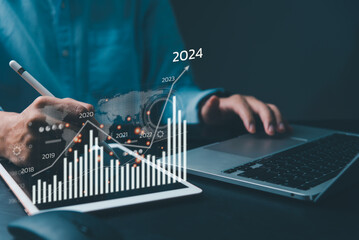 financial charts and graph analysis marketing showing growing revenue In 2024 floating above digital screen tablet, business about strategy for growth and success.