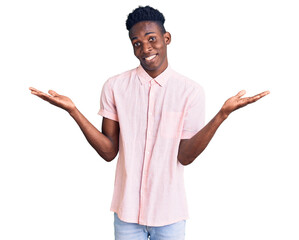 Young african american man wearing casual clothes clueless and confused expression with arms and...
