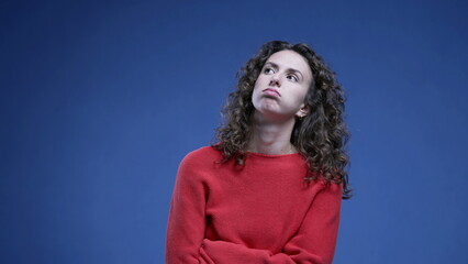 Woman feeling bored sighing deeply with arms crossed looking up and rolling eyes in boredom...