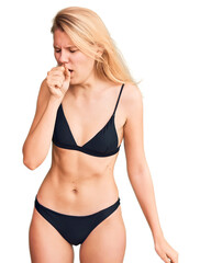 Fototapeta premium Young beautiful blonde woman wearing bikini feeling unwell and coughing as symptom for cold or bronchitis. health care concept.