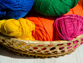 Rolls of colorful threads in a wicker basket. Colorful cotton cord.