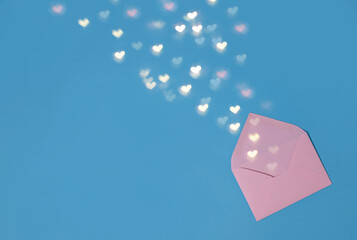 there is a pink envelope on a blue background and hearts are pouring out of the envelope