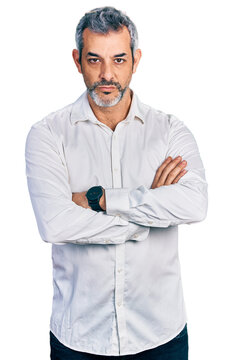 Middle age hispanic with grey hair wearing casual white shirt skeptic and nervous, disapproving expression on face with crossed arms. negative person.