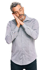Middle age grey-haired man wearing casual clothes sleeping tired dreaming and posing with hands together while smiling with closed eyes.