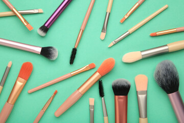 Professional female cosmetics brushes for makeup and eyelash brush on mint background. Cosmetics...