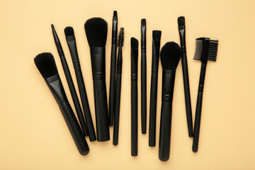 Professional black brushes for makeup and eyelash brush on beige background. Cosmetics concept, make up concept