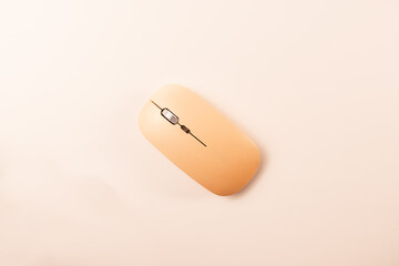 Overhead shot of a nude pink wireless computer mouse on a white background