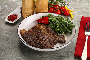 Grilled chuck roll steak with arugula