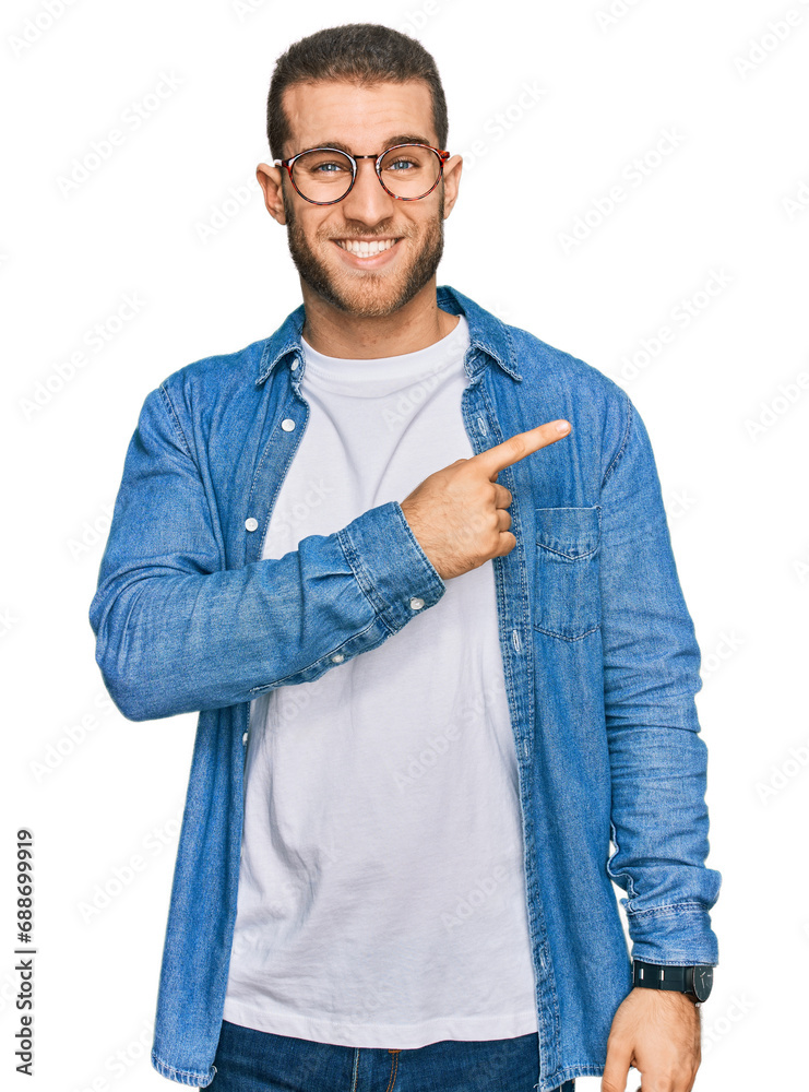 Wall mural Young caucasian man wearing casual clothes pointing aside worried and nervous with forefinger, concerned and surprised expression