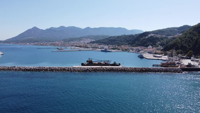 Aerial footage of shipyard in Karlovasi, Samos island behind wave breakers on a clear summer morning