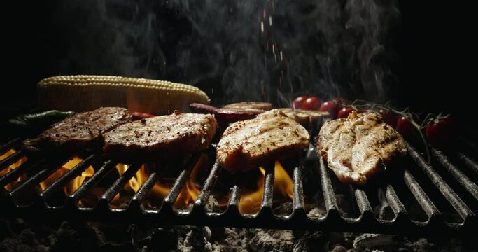 Delicious pieces chicken steak, fried until golden brown. Tongues of flame on black background. Juicy chicken fillet sprinkled with salt. Fragrant vegetables will make every dish unforgettable, AD