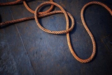 High angle view of the old giant fiber naytical rope on steel boat floor background in dark tone...