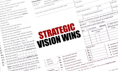 STRATEGIC VISION WINS on white sticker with tax forms