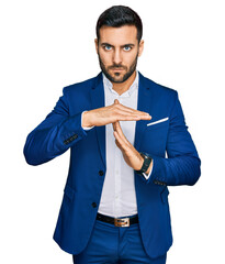 Young hispanic man wearing business jacket doing time out gesture with hands, frustrated and...
