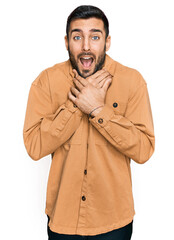 Young hispanic man wearing casual clothes shouting and suffocate because painful strangle. health problem. asphyxiate and suicide concept.