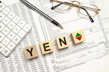 yen word on wooden blocks with calculator and pen