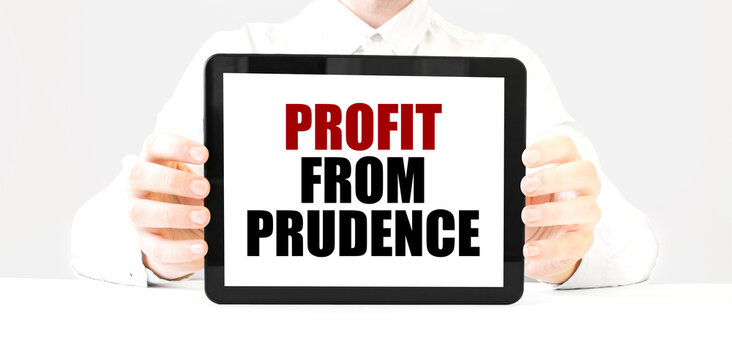 Text PROFIT FROM PRUDENCE on tablet display in businessman hands on the white background. Business concept