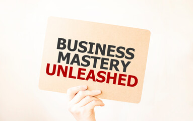 Closeup Business man hand holding show blank paper sheet BUSINESS MASTERY UNLEASHED