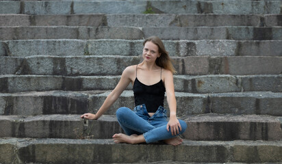 Fototapeta na wymiar Fashionable beautiful woman on the steps of a summer day