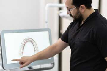 Bearded dentist demonstrating human jaws models on screen conducting lecture for students and...