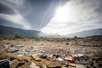 Polluted Landscape with Waste in Front of a Mountain Background - shot in Albania - obrazy, fototapety, plakaty