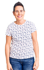 Obraz premium Young woman with short hair wearing casual clothes looking positive and happy standing and smiling with a confident smile showing teeth