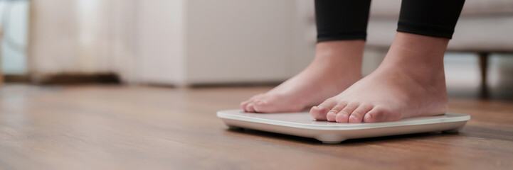 Woman feet standing on digital scales for diet control..